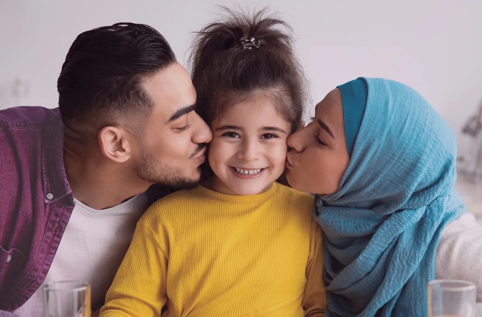 A family embracing a child at home
